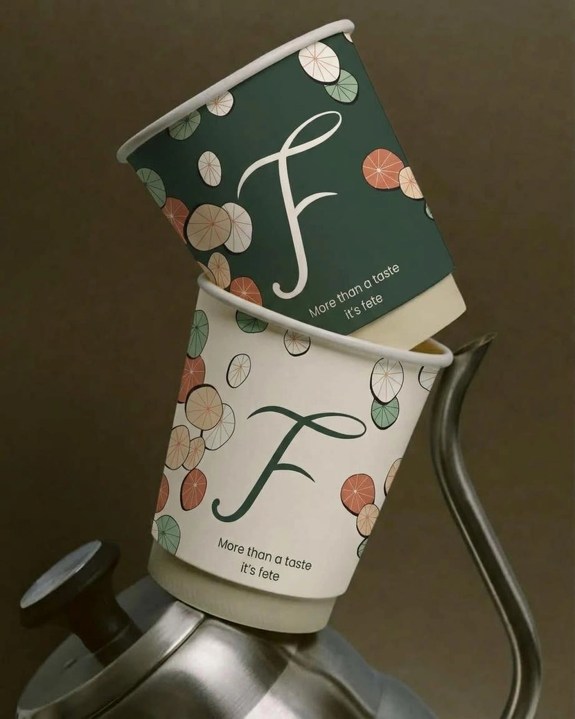 FETE branded cups with forest green and citrus artwork